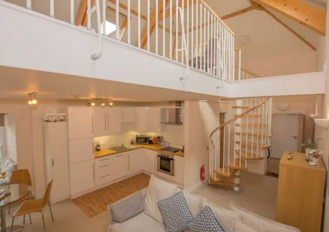 The spiral staircase leads up to the bedroom at Cobra House, Tenby