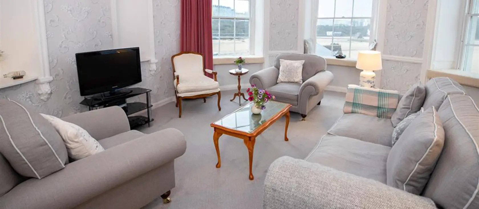 Laston House 2, Tenby is a unique ground-floor Regency apartment with panoramic sea views over Carmarthen Bay & Tenby's picturesque harbour. With three bedrooms, a circular lounge with ornate windows, and steps from beaches & historic town centre.