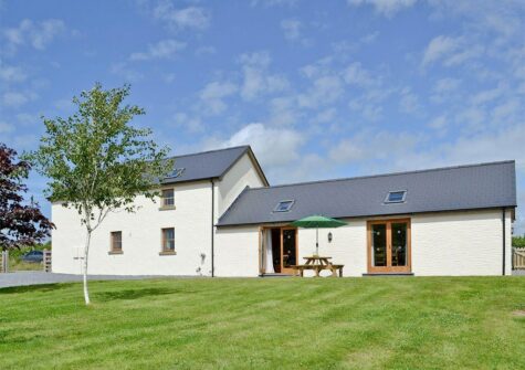 Llanlliwe Cottage, Henllan Amgoed is a four bedroom three bathroom barn conversion for eight near Narberth. The open plan living room has vaulted beamed ceiling, farmhouse kitchen & sitting area with French doors onto patio with rural views.
