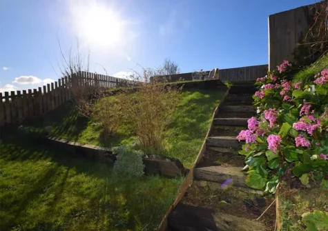 From the patio, steps lead up to the garden and patio