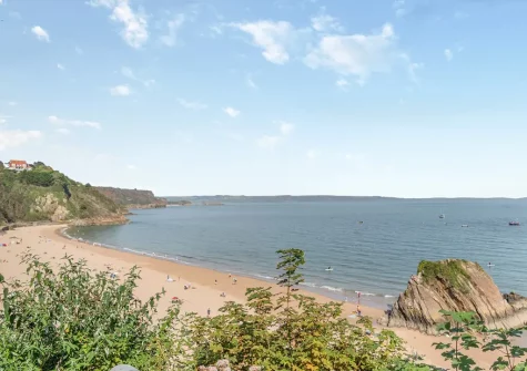 Tenby's North Beach is a long sandy beach set against a backdrop of cliffs on one side and Tenby town & the picturesque harbour on the other