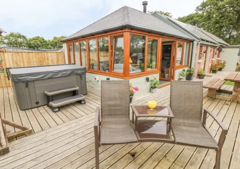 The decked patio, hot tub & alfresco dining area at The Old Farm Shop, Bethesda