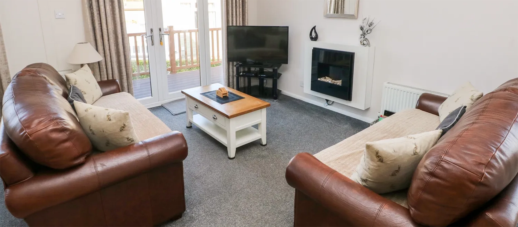 Tranquillity, Heritage Park is a luxury lodge close to the coast in Stepaside near Saundersfoot and Tenby. This three-bedroom chalet offers a modern, airy interior with an open-plan living space and large glass doors leading to a wrap-around deck.